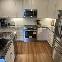 Bright white kitchen remodel with marble waterfall countertops