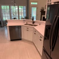 White kitchen with corner sink and stainless appliances